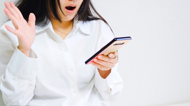 スマホを見て驚く女性