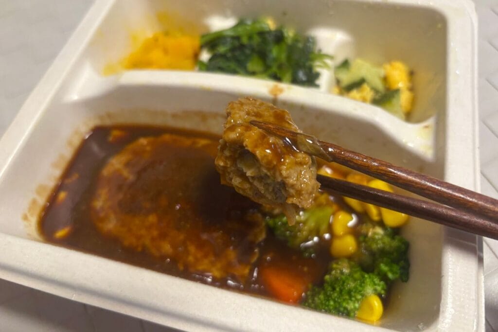 ハンバーグと彩り温野菜のデミ 箸で持ったところ